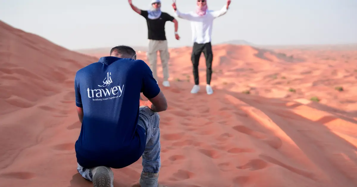 Trawey Tours guide providing a private desert photography session for a group during a sunrise safari in Dubai.